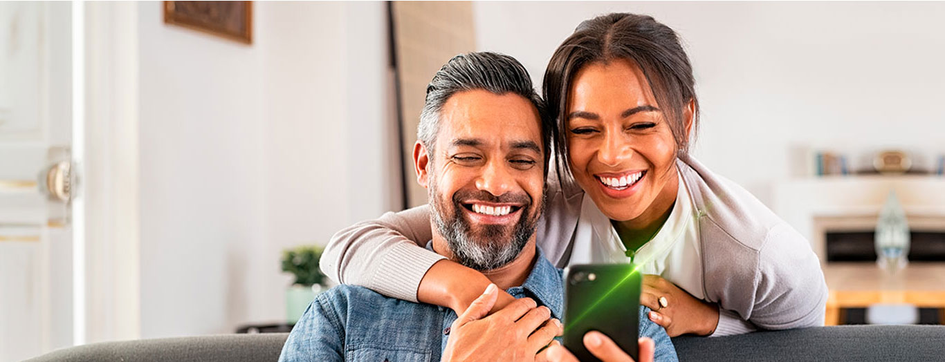 Pareja feliz viendo la rentabilidad que genera su cuenta para ahorrar del Popular